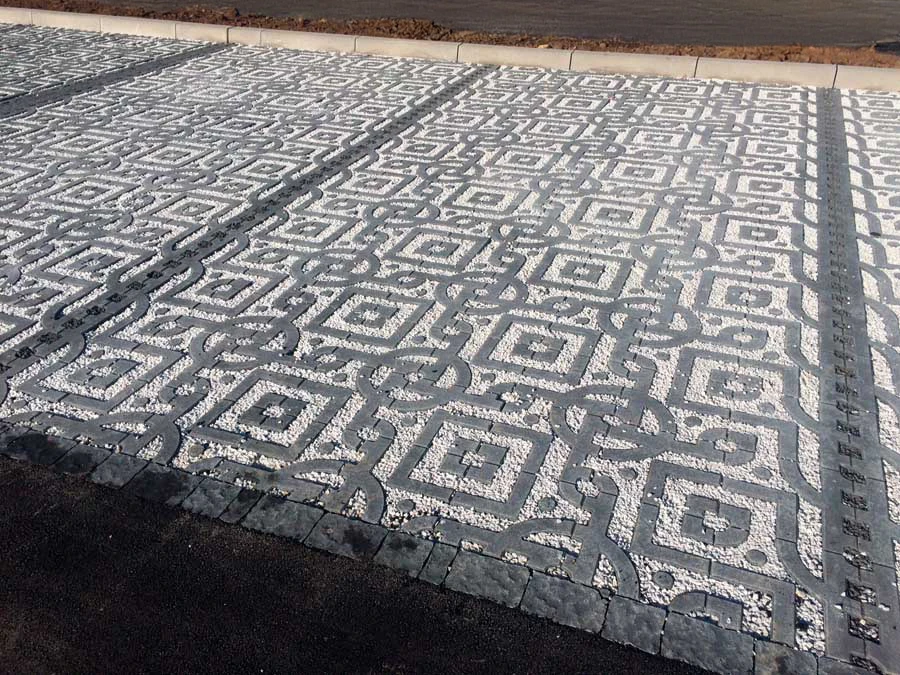 Jardin résidentiel avec portail d'entrée, allées pavées et aménagements paysagers