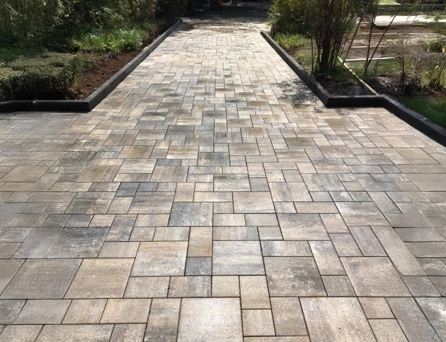 Terrasse extérieure d'établissement avec mobilier moderne coloré, tables turquoise et corail, chaises noires, canapés en résine tressée