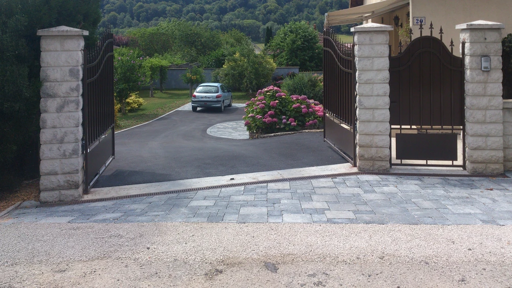 Espace de réunion moderne avec table ronde grise et quatre chaises colorées disposées sur terrasse carrelée