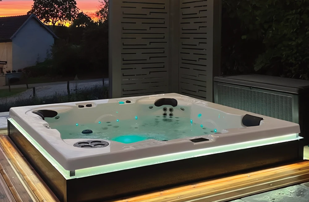 Terrasse extérieure avec spa jacuzzi encastré dans habillage bois teck, vue panoramique sur paysage méditerranéen et océan