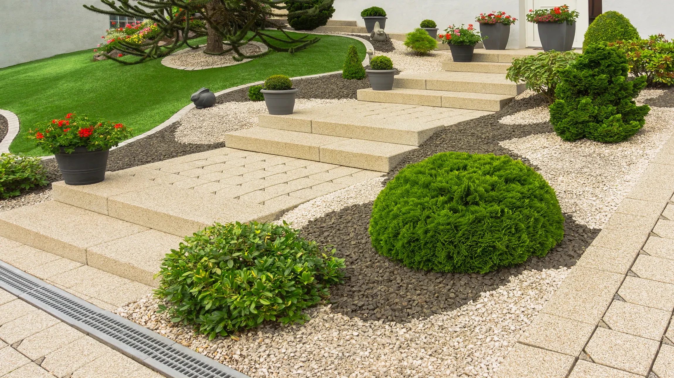 Terrasse extérieure avec salon de jardin moderne comprenant canapé deux places, deux fauteuils et tables basses rondes