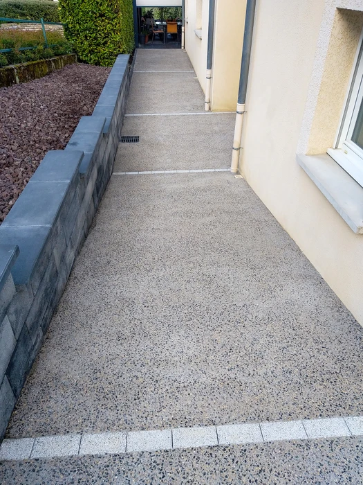 Allée de gravier menant à une maison en briques rouges avec jardinage paysager