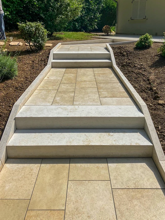 Allée de gravier menant à une maison en briques rouges avec jardinage paysager